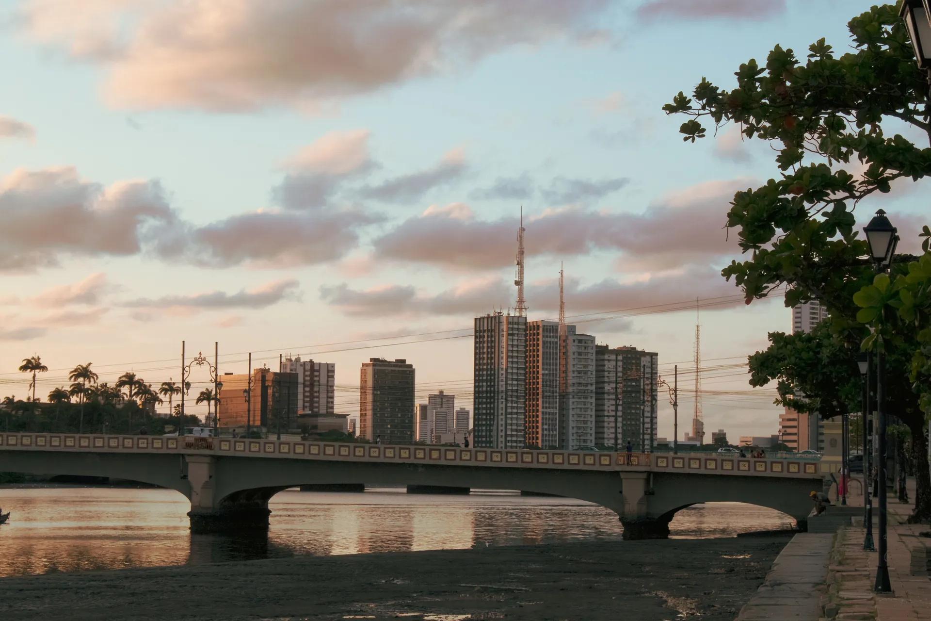 Ponte sobre o rio Capibaribe no Recife, com os prédios da cidade na luz dourada do fim de tarde